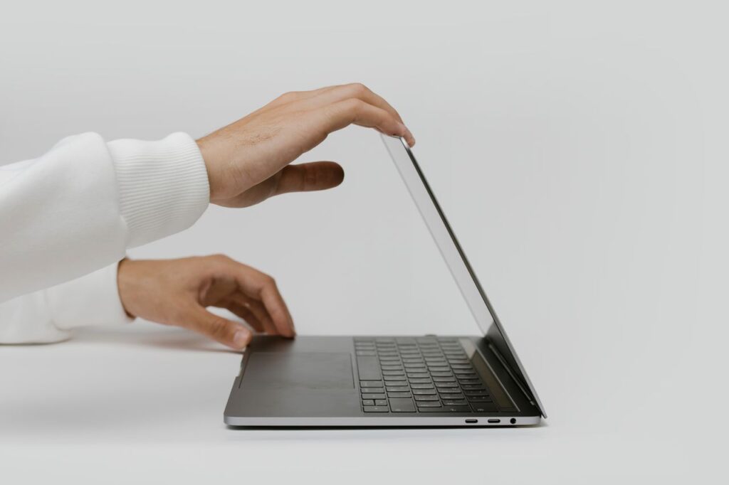 Mãos empurrando levemente o notebook, indicando uma pausa ou limite - a arte de dizer não