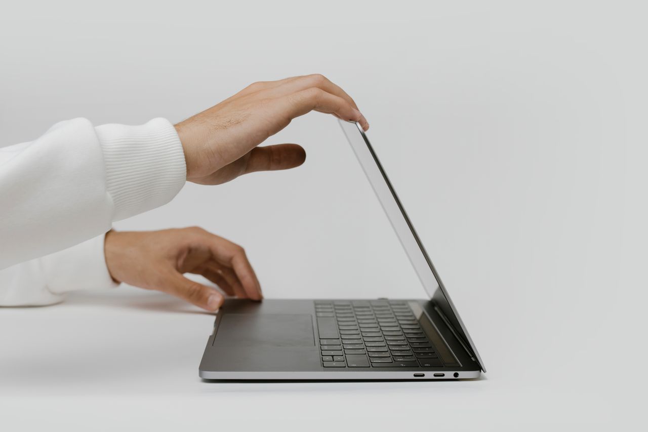 Mãos empurrando levemente o notebook, indicando uma pausa ou limite - a arte de dizer não