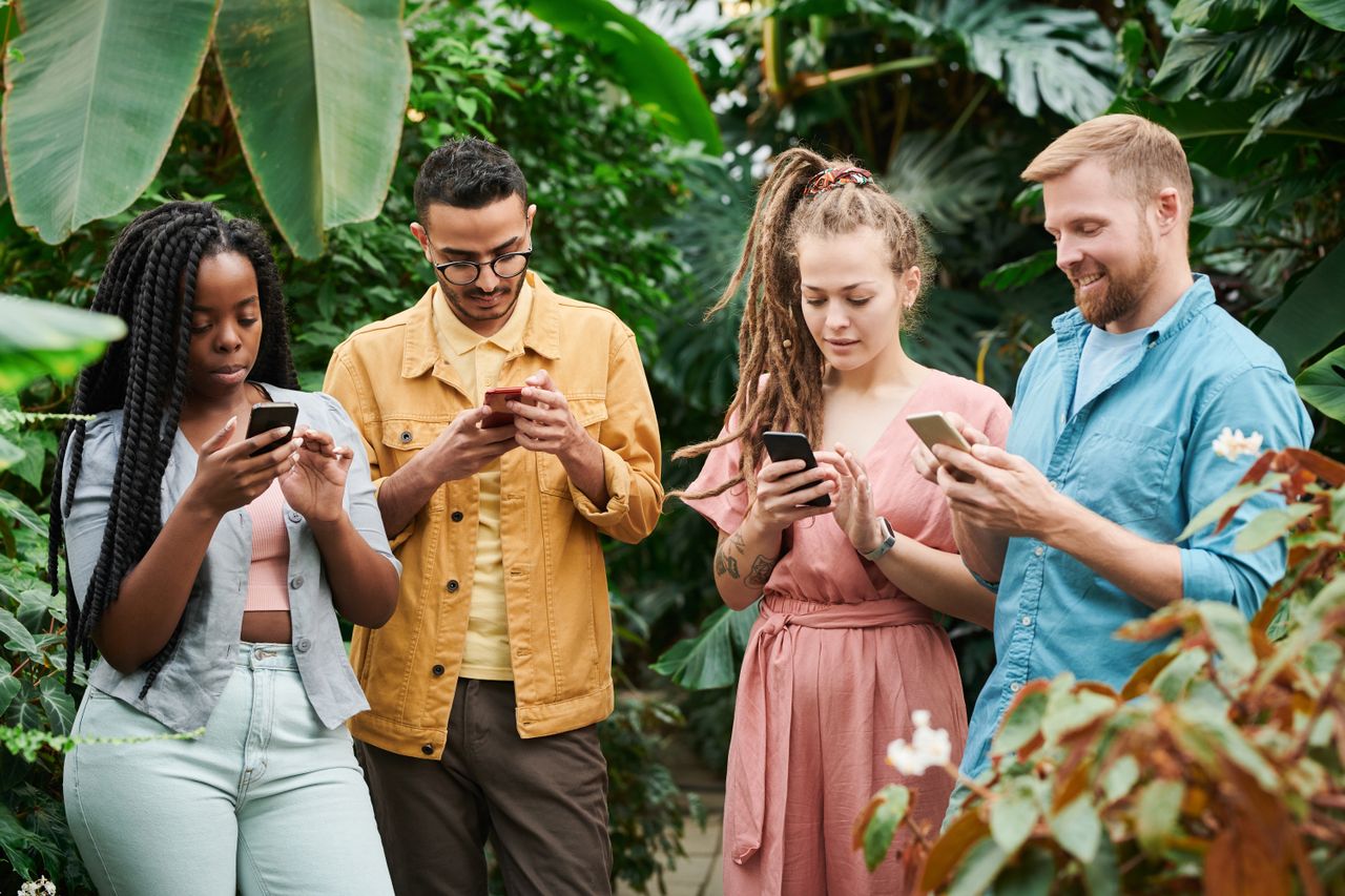 Grupo de pessoas sentadas juntas, mas cada uma olhando para o seu próprio celular - conexoes liquidas