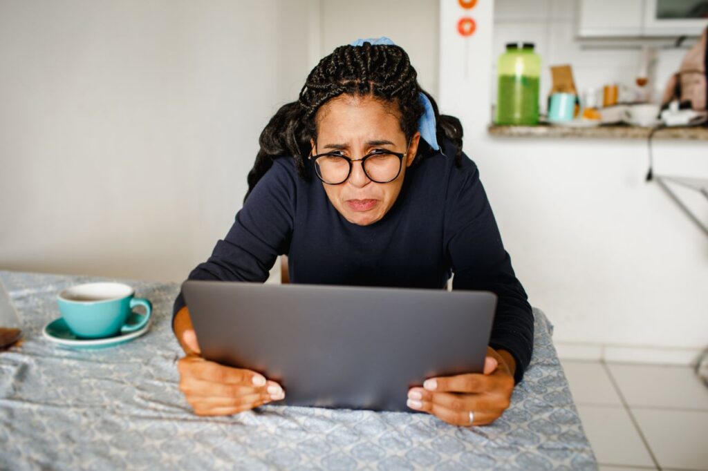 Pessoa olhando para a tela do notebook com expressão preocupada - sindrome do impostor no home office
