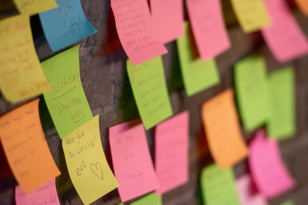 Post-its colados na mesa de trabalho ou parede com anotações organizadas - sindrome do impostor no home office