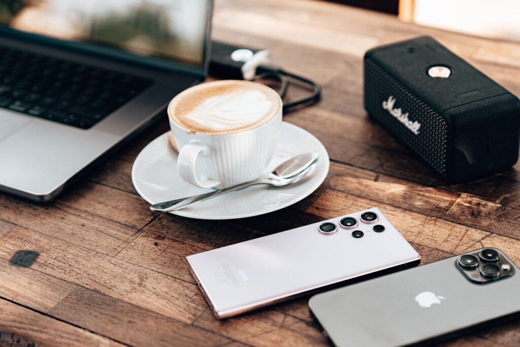 Celular virado de cabeça para baixo na mesa ao lado de uma xícara de café - ansiedade de informação