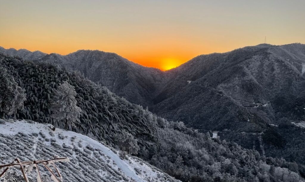 a arte de falhar e recomeçar - Uma paisagem gélida e majestosa iluminada pelos tons alaranjados e dourados de um sol nascente sobre o horizonte de neve