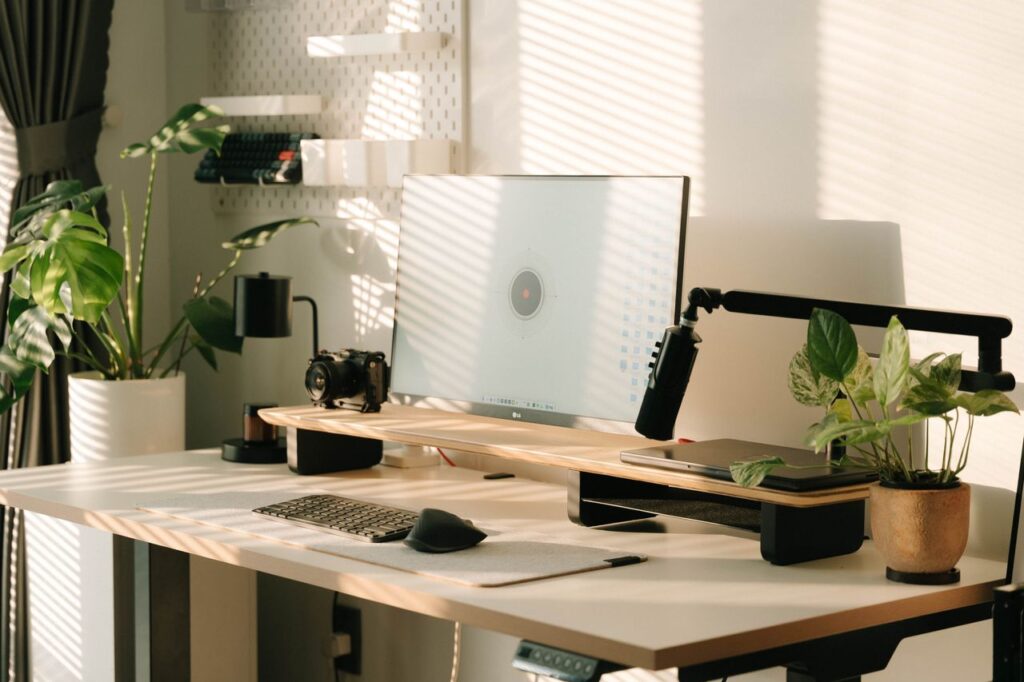 aperfeiçoamento continuo -Um espaço de trabalho minimalista, limpo e organizado, iluminado pela luz natural do dia, com poucos objetos e uma planta ao lado
