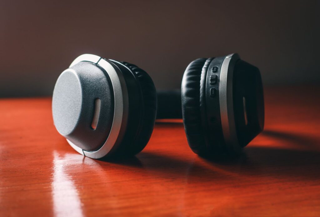 cultura da hiperconexao - Close em fones de ouvido deixados de lado em uma mesa de madeira, indicando pausa