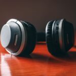 cultura da hiperconexao - Close em fones de ouvido deixados de lado em uma mesa de madeira, indicando pausa