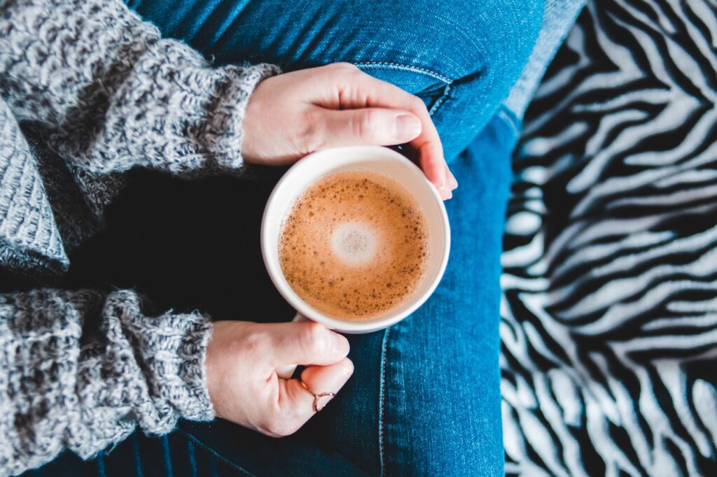 aperfeiçoamento continuo -Alguém segurando uma caneca quente com as duas mãos em um ambiente sereno