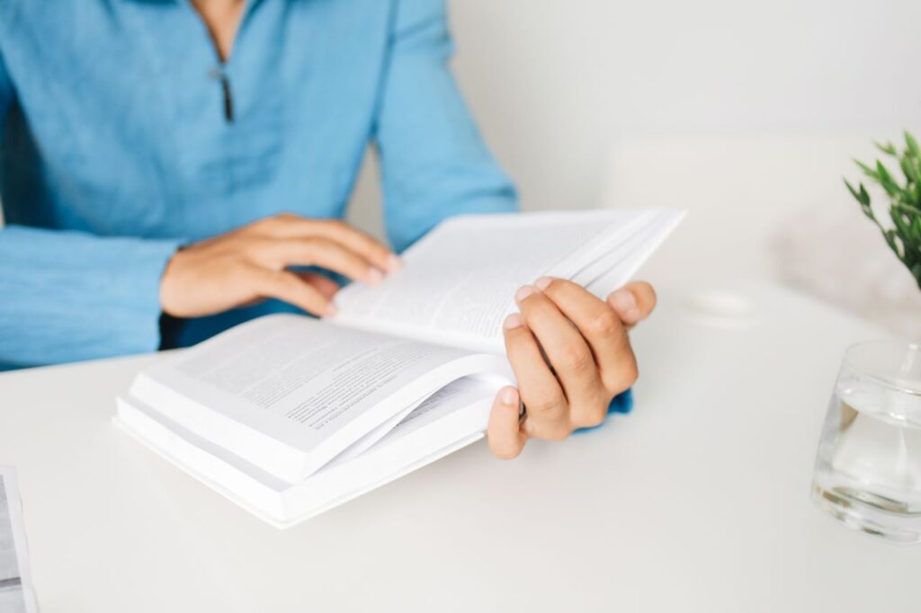 economia da distracao - Pessoa relaxada lendo um livro físico em um ambiente limpo e iluminado