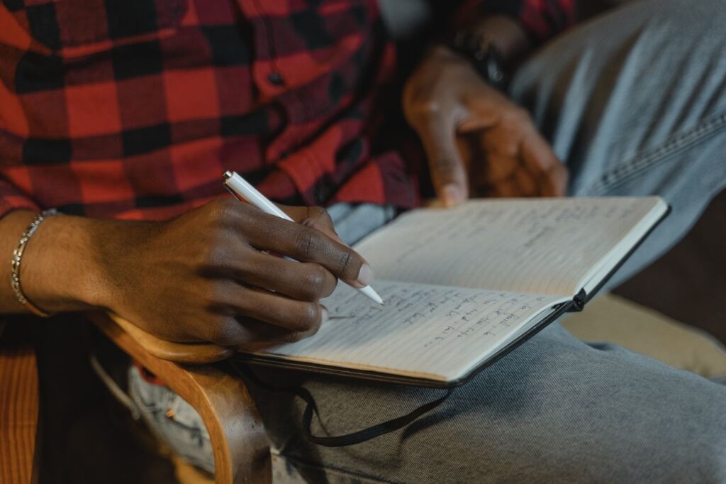 recomeçar na vida adulta - Uma cena em ângulo fechado de alguém anotando ideias com calma em um caderno ou mapa conceitual, com elementos que sugerem reflexão profunda