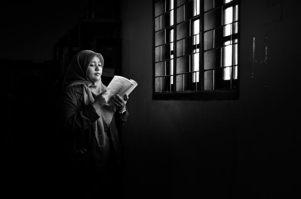 seneca - retrato em estilo soturno com luz e sombra marcadas de alguém lendo um livro antigo ou escrevendo em um diário ao lado de uma janela com luz natural