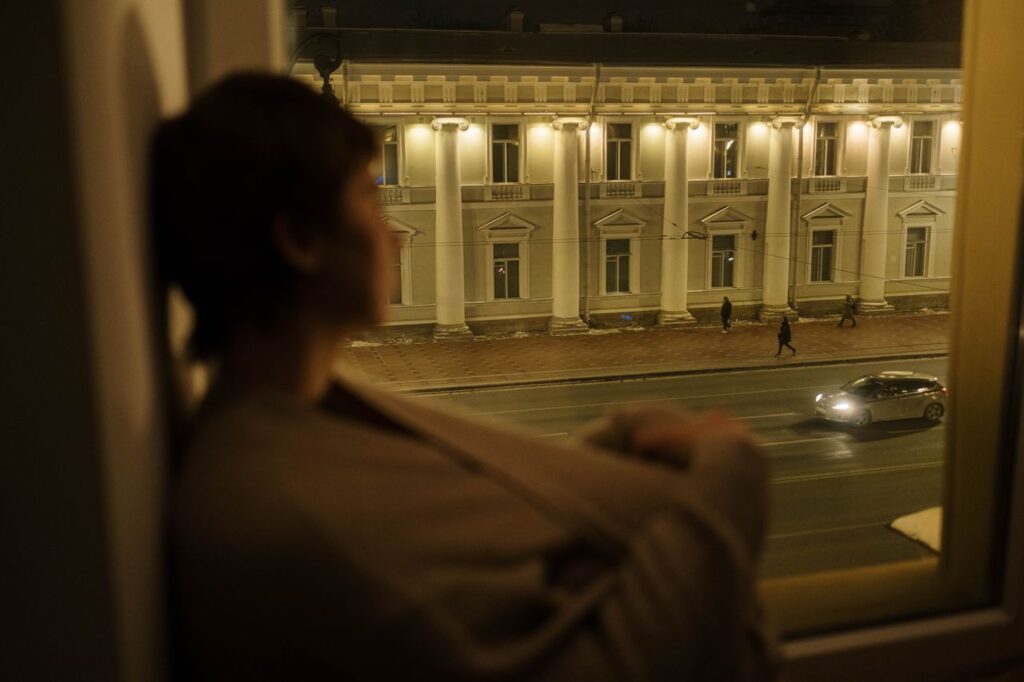 autismo em adultos - pessoa aconchegada próxima a uma janela ou em um canto tranquilo da casa, em iluminação suave e ambiente neutro