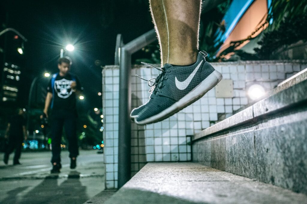 frase motivacional curta - close-up dinâmico focando nos pés/sapatos de alguém dando um passo decisivo em uma escadaria ou pista de corrida