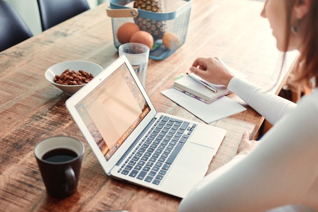 frase motivacional curta - mesa de trabalho organizada, com um notebook, uma xícara de café e um bloco de notas com uma caneta