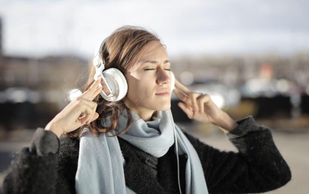 autismo em adultos - adulto em um ambiente calmo ou de trabalho usando fones de ouvido grandes, com expressão tranquila ou de olhos fechados