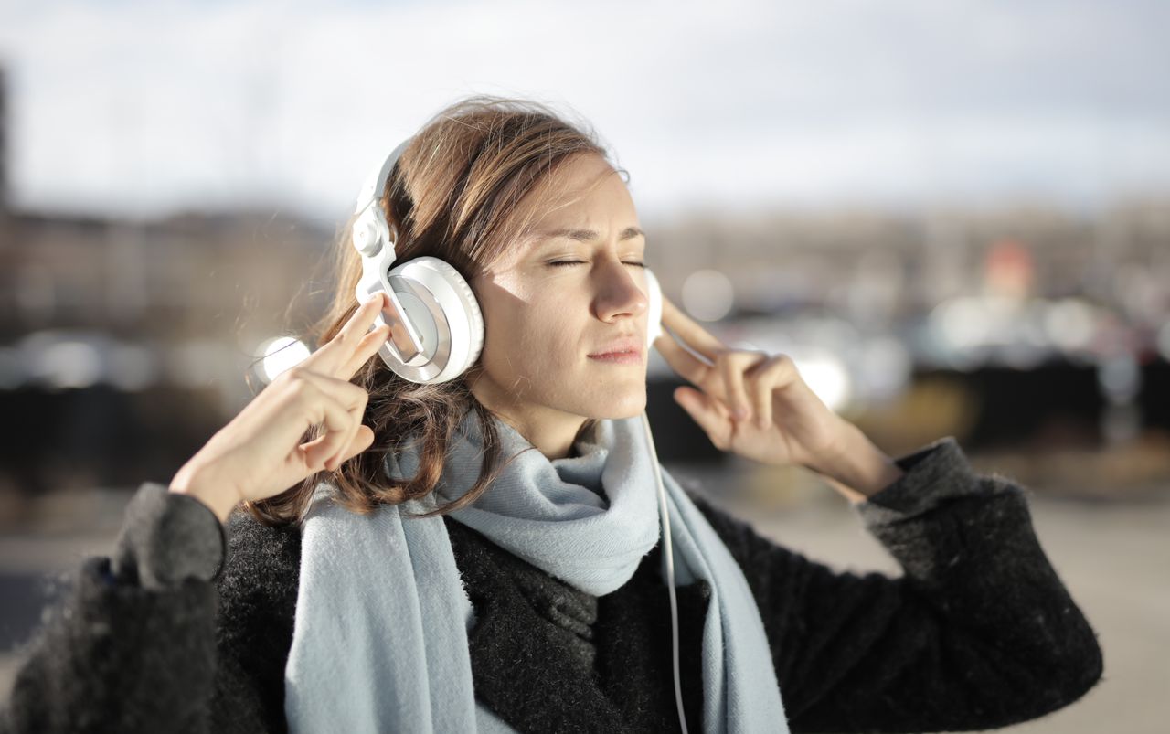 autismo em adultos - adulto em um ambiente calmo ou de trabalho usando fones de ouvido grandes, com expressão tranquila ou de olhos fechados