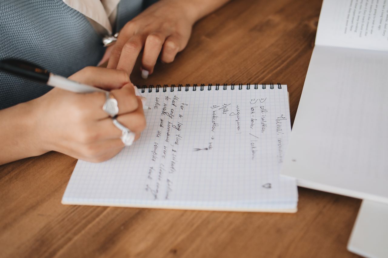 ferramenta de autoajuda - pessoa sentada em uma mesa limpa e organizada, escrevendo em um planner