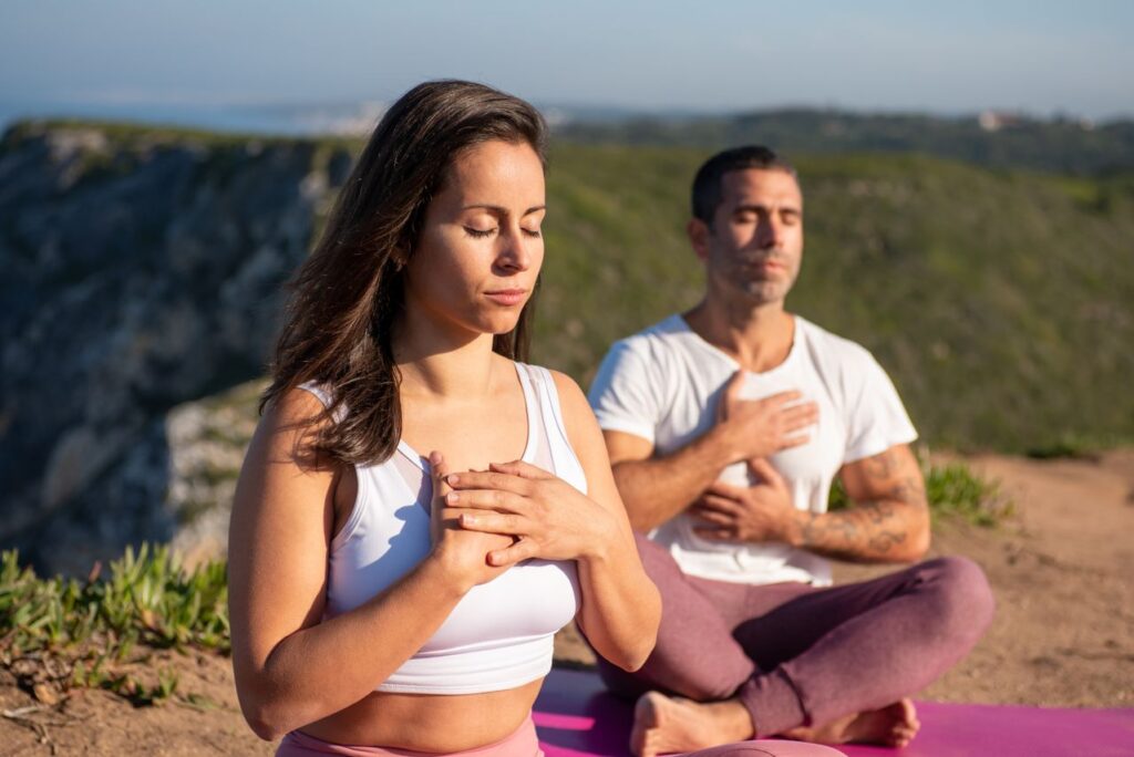 padrões mentais - pessoa em momento de quietude, com as mãos suavemente no peito ou olhos fechados respirando fundo ao ar livre ou em um ambiente acolhedor