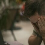 exautão no linkedin - profissional em frente ao laptop ou segurando o smartphone com a cabeça apoiada nas mãos ou expressão de exaustão