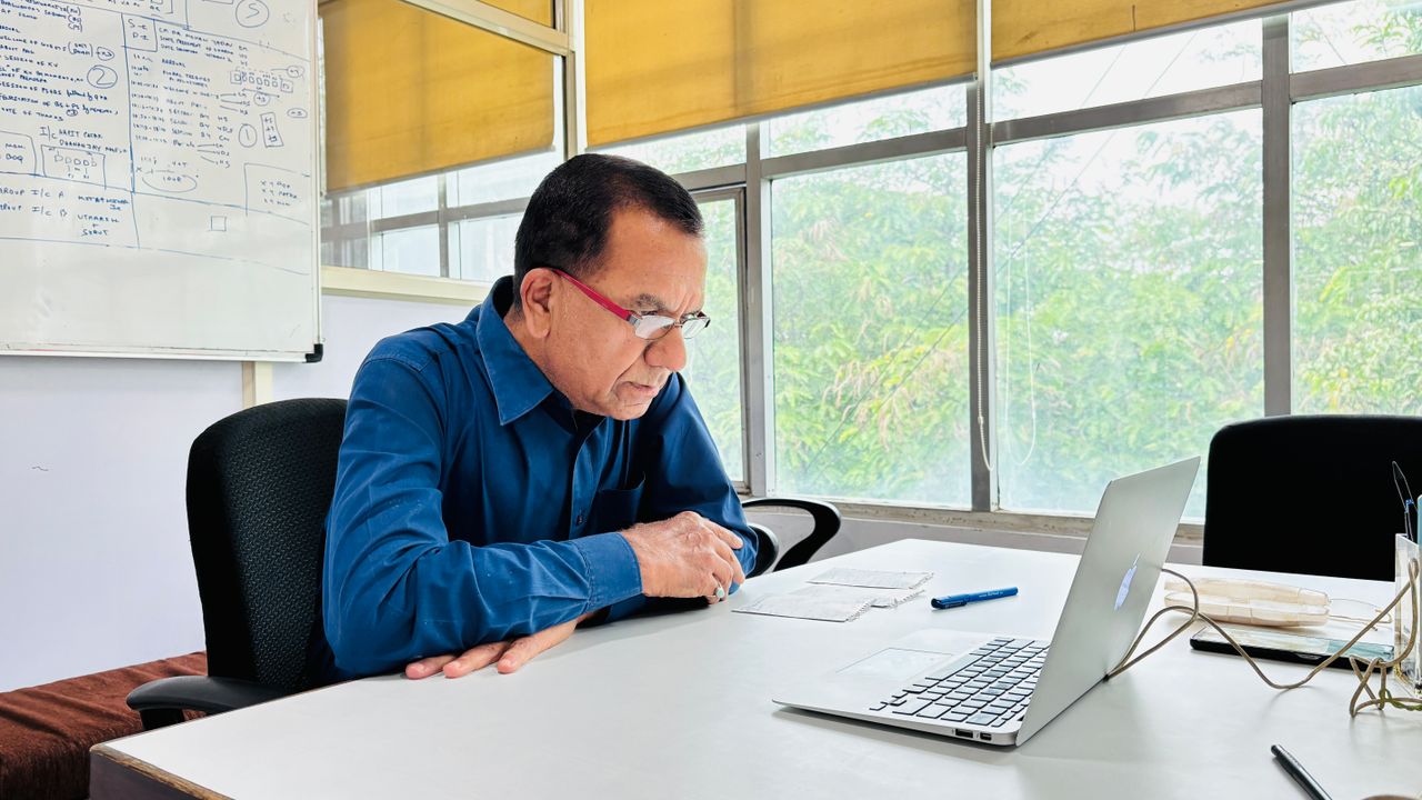 Reinvenção Profissional Após os 40 e 50 Anos - profissional de meia-idade sorrindo com postura confiante em frente a um laptop ou em uma sala de reuniões iluminada