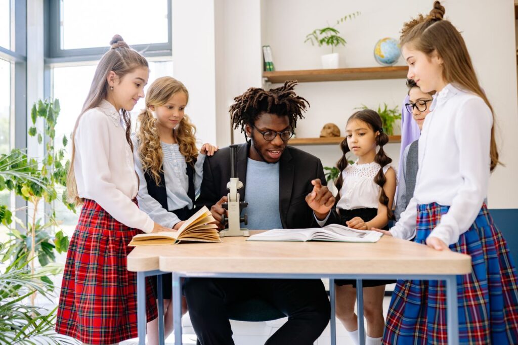 projetos sociais - educador ou mentor interagindo de forma próxima e entusiasmada com alunos em uma sala de aula